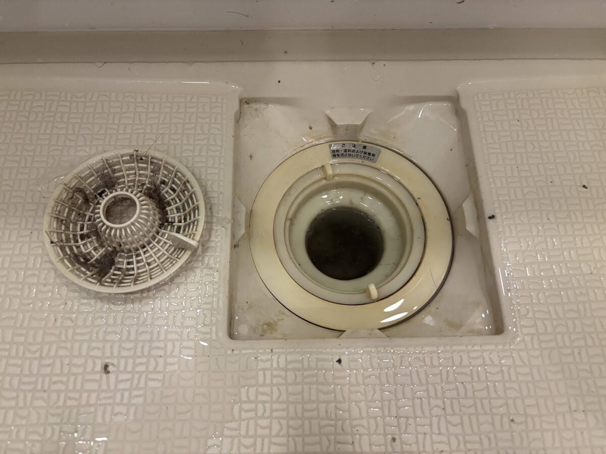 髪の毛や汚れが付着した清掃前の浴室排水口