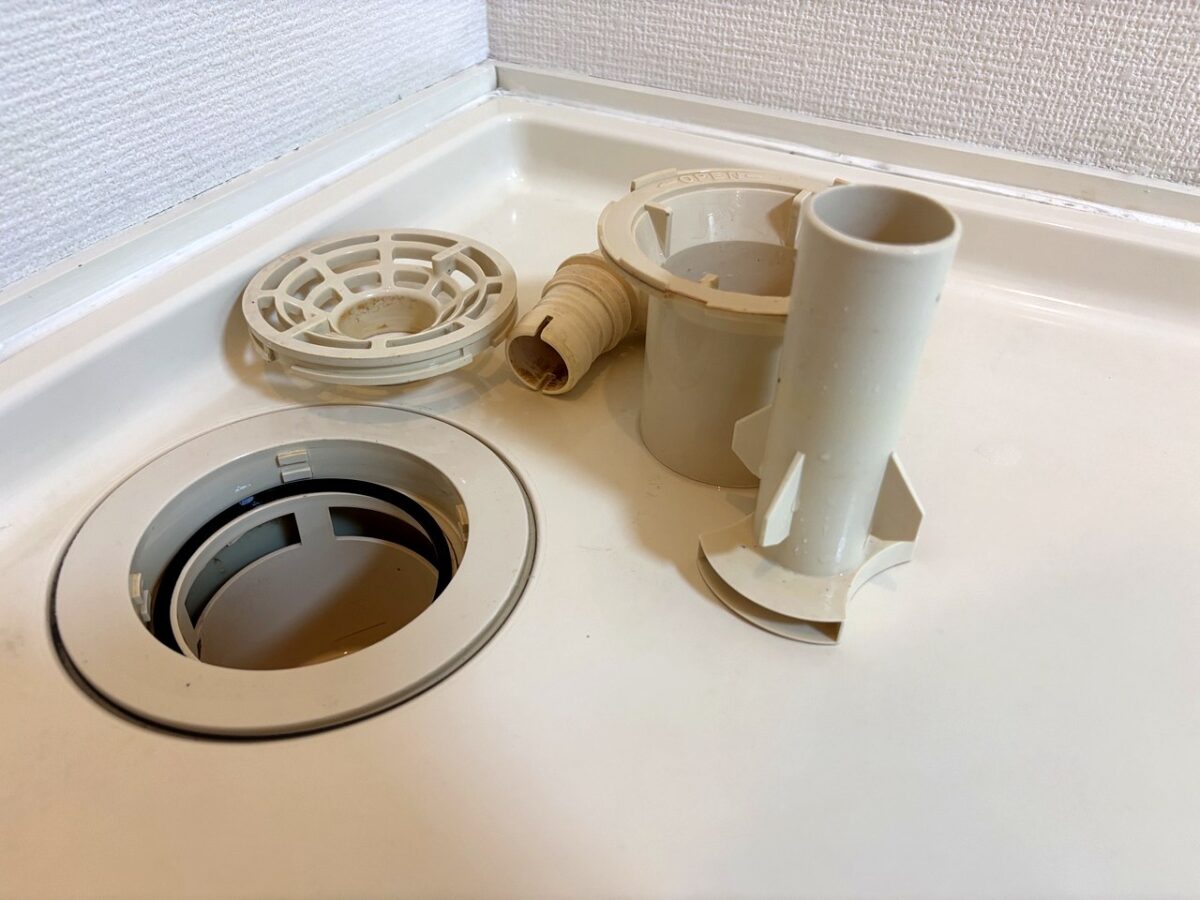 洗濯機防水パンの排水部品を分解して並べた状態